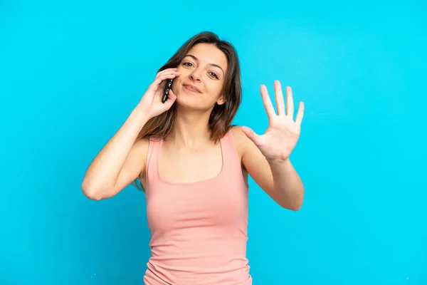 Giovane Donna Caucasica Utilizzando Telefono Cellulare Isolato Sfondo Blu Contando — Foto Stock