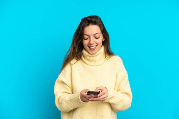 Молодая Белая Женщина Изолированная Синем Фоне Отправляет Сообщение Мобильным Телефоном — стоковое фото