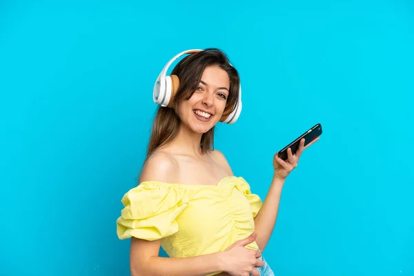Joven Mujer Caucásica Aislada Sobre Fondo Azul Escuchando Música Haciendo —  Fotos de Stock