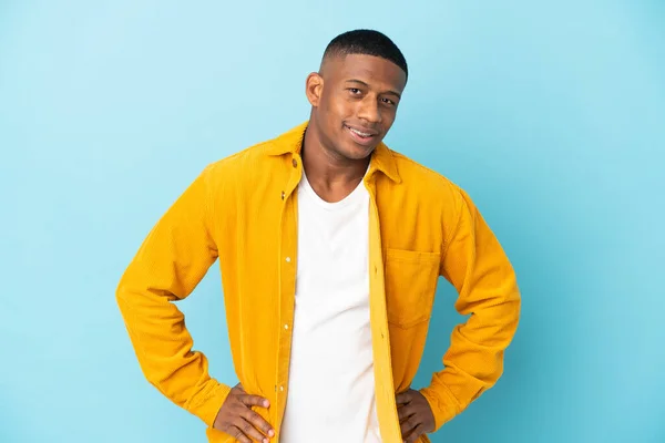 Young Latin Man Isolated Blue Background Posing Arms Hip Smiling — Foto Stock