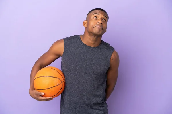 年轻的蓝天篮球运动员 被紫色背景隔离 仰视着 — 图库照片