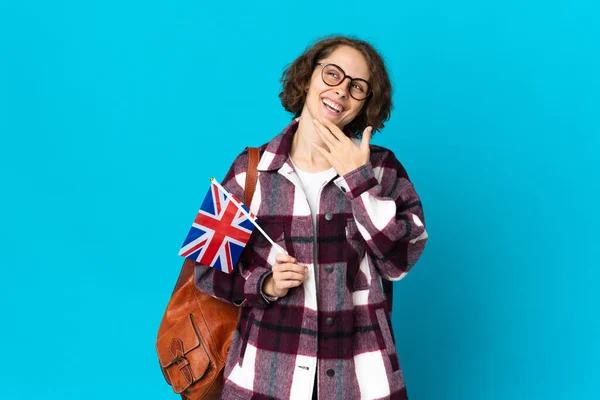 Młoda Angielka Trzymająca Flagę Zjednoczonego Królestwa Odizolowana Niebieskim Tle Uśmiechnięta — Zdjęcie stockowe