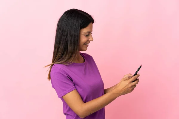 분홍색 배경에 고립되어 휴대폰으로 메시지나 이메일을 보내는 — 스톡 사진