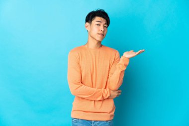 Mavi arka planda mahsur kalmış genç Çinli adamın şüpheleri var.