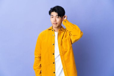 Mor arka planda mahsur kalmış genç Çinli adamın şüpheleri var.