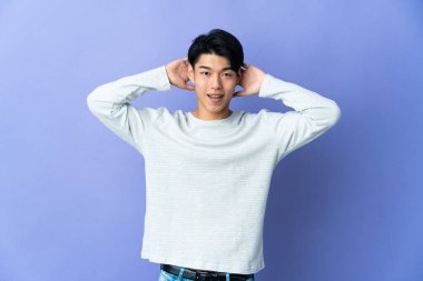 Mor arka planda yalnız yaşayan genç bir Çinli gülüyor.