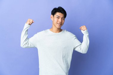 Mor arka planda izole edilmiş genç bir Çinli güçlü bir jest yapıyor.