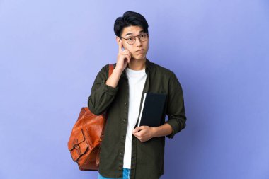 Mor arka planda izole edilmiş genç bir bayan bir fikir düşünüyor.