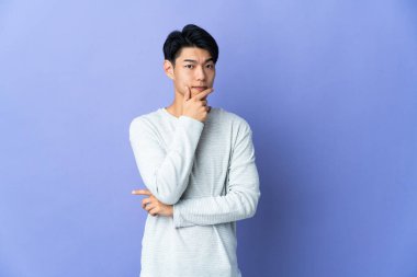 Mor arka planda mahsur kalmış genç Çinli adamın şüpheleri var.