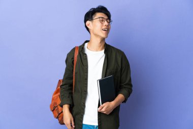 Mor arka planda izole olmuş genç bayan gülüyor.