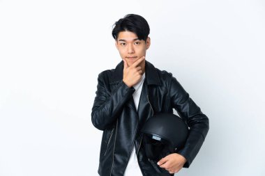Chinese man with a motorcycle helmet isolated on white background thinking