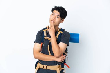 Dağcı Çinli adam beyaz arka planda izole edilmiş, yukarı bakarken şüpheleri var.