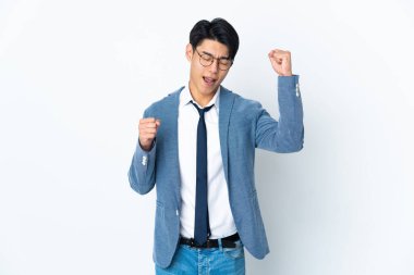 Genç Çinli iş adamı beyaz arka planda zaferi kutluyor.