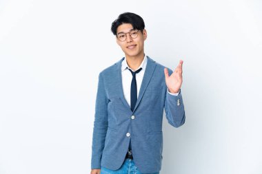 Genç Çinli iş adamı beyaz arka planda izole edilmiş, mutlu bir ifadeyle selamlanıyor.