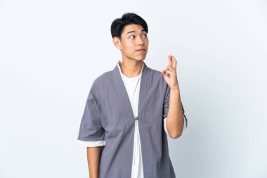 Genç Çinli adam beyaz arka planda izole edilmiş ve şans diliyor.