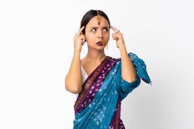 Genç Hintli kadın beyaz arka planda izole edilmiş. Şüpheleri ve düşünceleri var.