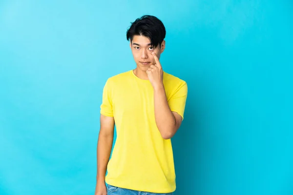 Young Chinese Man Isolated Blue Background Showing Something — Stockfoto