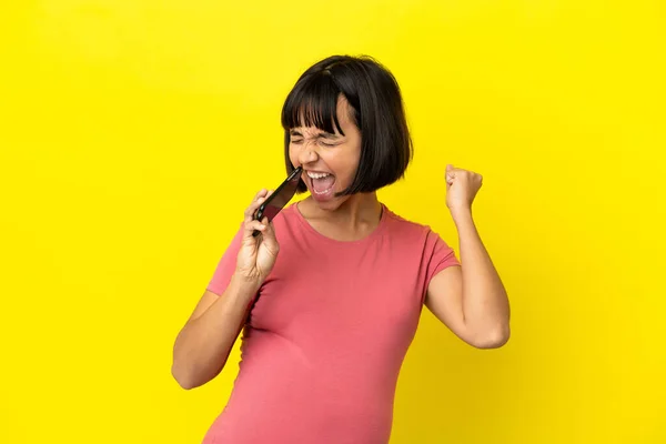 Young Mixed Race Pregnant Woman Isolated Yellow Background Using Mobile — Stock fotografie