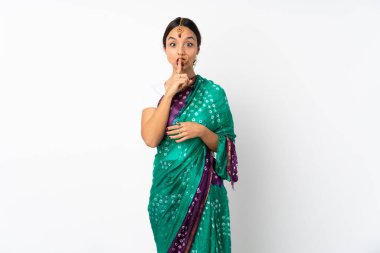 Beyaz arka planda izole edilmiş genç Hintli kadın sessiz bir jest işareti gösteriyor. Parmağını ağzına sokuyor.