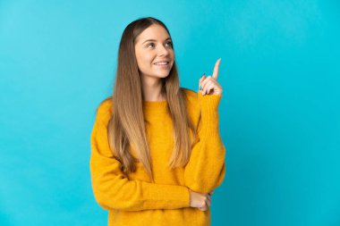 Genç Litvanyalı kadın mavi arka planda izole edilmiş. Harika bir fikre işaret ediyor.