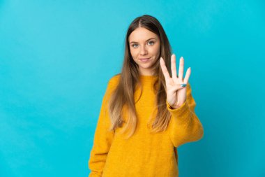 Genç Litvanyalı kadın mavi arka planda izole edilmiş mutlu ve parmaklarıyla dörde kadar sayıyor.