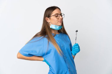 Litvanyalı kadın diş hekimi, arka planda izole edilmiş aletler tutuyor.