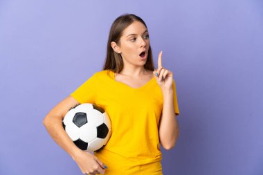 Genç Litvanyalı futbolcu kadın, mor arka planda izole edilmiş bir şekilde parmak kaldırmayı düşünüyor.