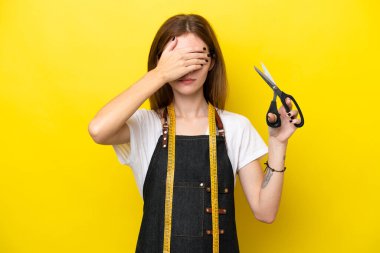 Genç terzi İngiliz kadın sarı arka planda tek başına gözlerini elleriyle kapatıyor. Bir şey görmek istemiyorum.