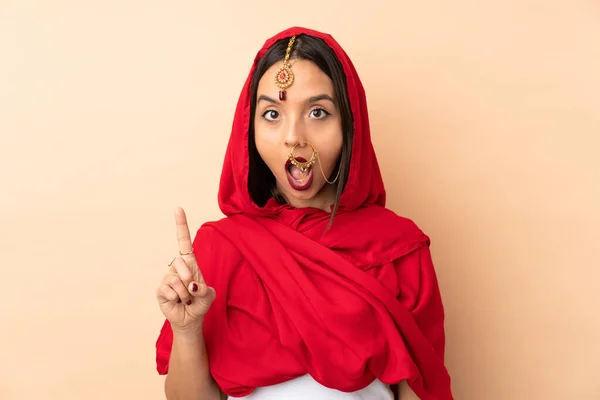 Mladá Indická Žena Izolované Béžové Pozadí Myšlení Nápad Ukazuje Prst — Stock fotografie