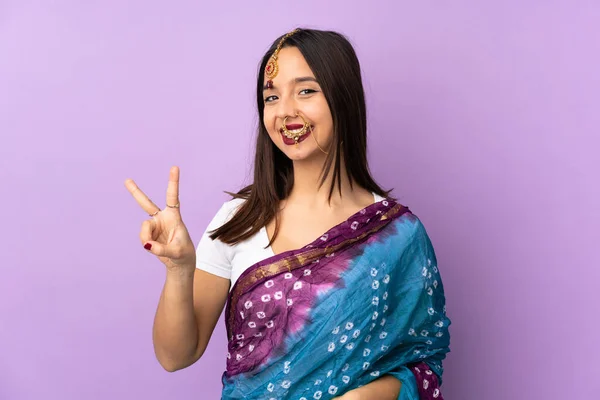Молодая Индийская Женщина Изолирована Фиолетовом Фоне Улыбаясь Показывая Знак Победы — стоковое фото