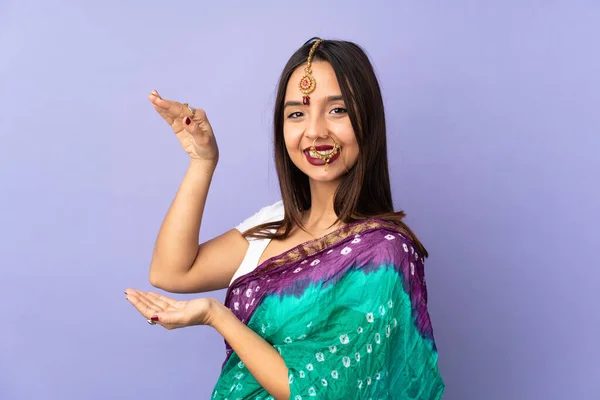 Young Indian Woman Isolated Purple Background Holding Copyspace Insert — стокове фото