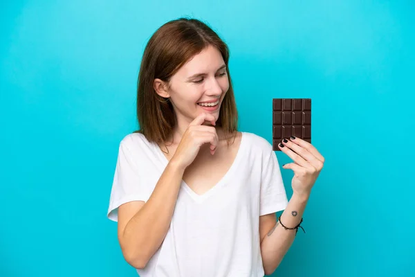Mladá Anglická Žena Čokoládou Izolované Modrém Pozadí Dívá Strany Usmívá — Stock fotografie