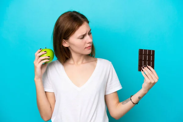 Mladá Anglická Žena Izolovaná Modrém Pozadí Pochybnostmi Při Užívání Čokoládové — Stock fotografie