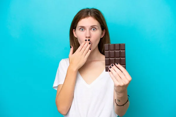 Mladá Anglická Žena Izolované Modrém Pozadí Čokoládovou Tabletu Překvapený — Stock fotografie