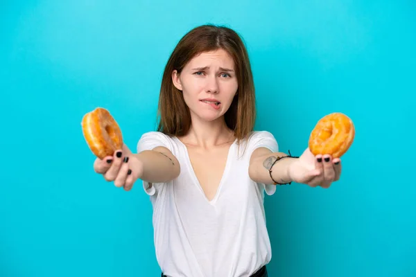 Young English Woman Isolated Blue Background Holding Donut Sad — стоковое фото