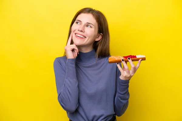 Young English Woman Holding Sashimi Isolated Yellow Background Thinking Idea — стоковое фото