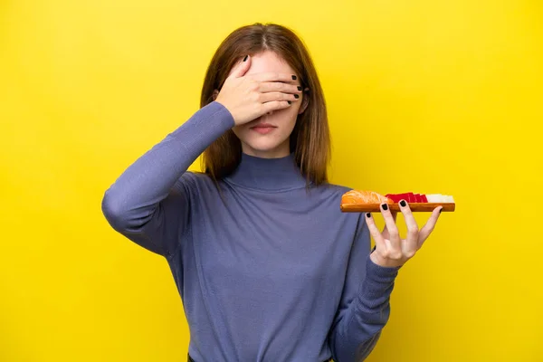 Young English Woman Holding Sashimi Isolated Yellow Background Covering Eyes — стокове фото