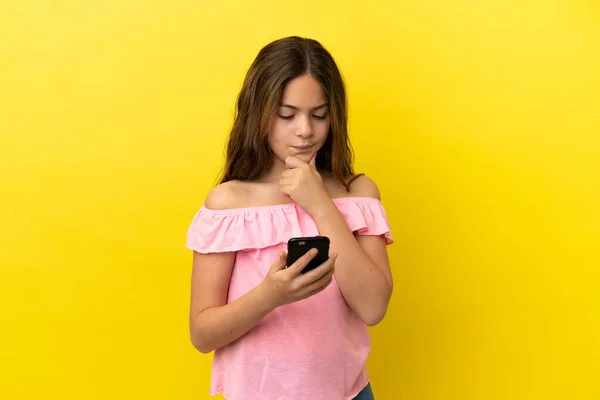 Pequeña Chica Caucásica Aislada Sobre Fondo Amarillo Pensando Enviando Mensaje —  Fotos de Stock