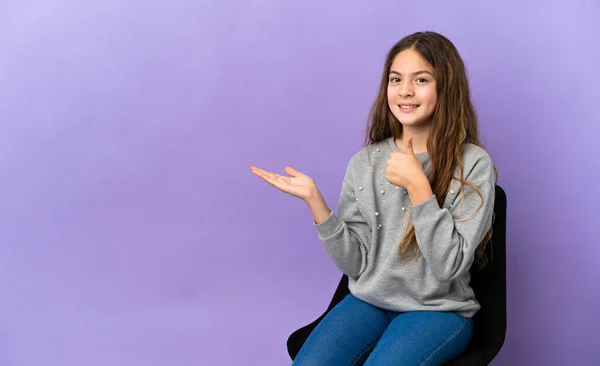 Little Caucasian Girl Sitting Chair Isolated Purple Background Holding Copyspace — 스톡 사진