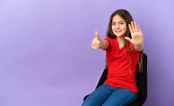 Little Caucasian Girl Sitting Chair Isolated Purple Background Counting Six — ストック写真