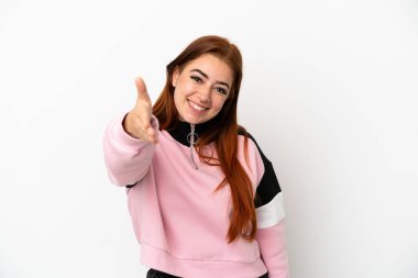 Beyaz arka planda izole edilmiş genç, kızıl saçlı bir kadın iyi bir anlaşma için el sıkışıyor.