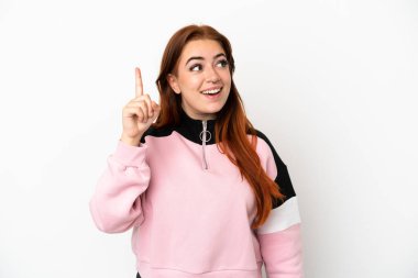 Genç kızıl saçlı kadın, beyaz arka planda izole edilmiş bir şekilde parmağını kaldırarak çözümü bulmaya çalışıyor.