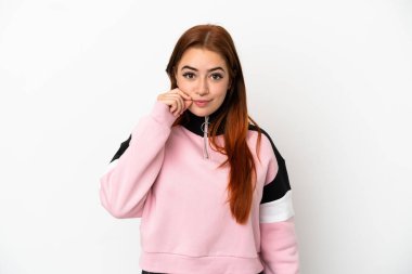 Beyaz arka planda izole edilmiş genç kızıl saçlı kadın sessizlik işareti gösteriyor.