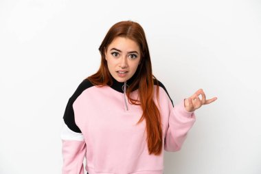 Beyaz arka planda izole edilmiş genç kızıl saçlı kadın şüpheli hareketler yapıyor.