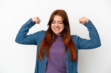 Genç kızıl saçlı kadın beyaz arka planda izole edilmiş güçlü bir jest yapıyor.