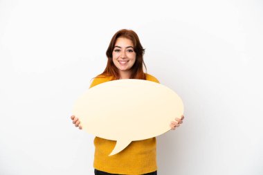 Beyaz arka planda izole edilmiş genç kızıl saçlı kadın boş bir konuşma balonu tutuyor.