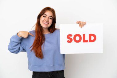 Genç kızıl saçlı kadın beyaz arka planda izole edilmiş. Elinde yazılı bir pankart var.