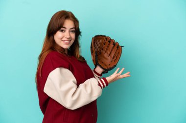 Beyzbol oynayan genç kızıl saçlı kadın, mavi arka planda soyutlanmış ve davet edildiği için ellerini yana uzatıyor.