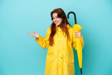 Mavi arka planda şemsiyesi olan kızıl saçlı kadın davet etmek için ellerini yana uzatıyor.