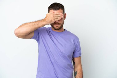 Genç Brezilyalı adam beyaz arka planda izole edilmiş, gözleri elle kaplanmış. Bir şey görmek istemiyorum.